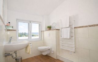 Helles Badezimmer mit Fenster und Handtuchheizkörper im Obergeschoss des Ferienhauses Mira-Belle 1 in Kühlungsborn