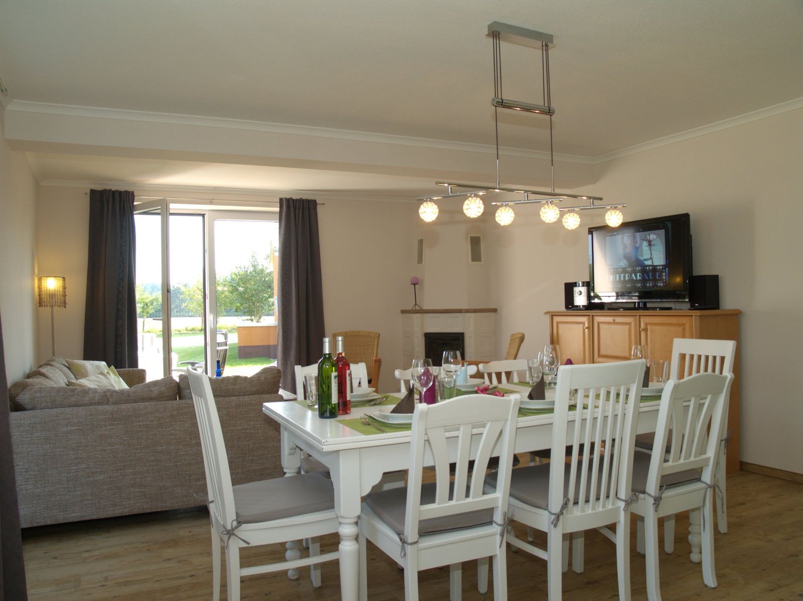 Essbereich mit Tisch für acht Personen, Kamin und Gartenblick im Ferienhaus Mira-Belle 1