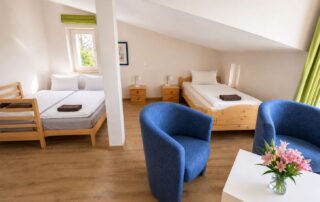 Familienzimmer im Dachgeschoss mit Doppelbett, Einzelbett und Sitzecke im Ferienhaus Mira-Belle 1