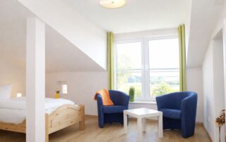 Dachzimmer mit Sitzecke und Blick ins Grüne im Ferienhaus Mira-Belle 1 in Kühlungsborn