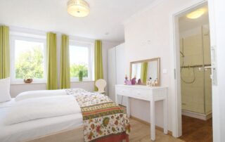 Schlafzimmer mit Doppelbett und eigenem Duschbad im Erdgeschoss des Ferienhauses Mira-Belle 1