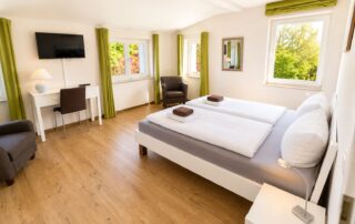 Großes Schlafzimmer mit Doppelbett, Sitzecke, Schreibtisch und TV im Ferienhaus Mira-Belle 1