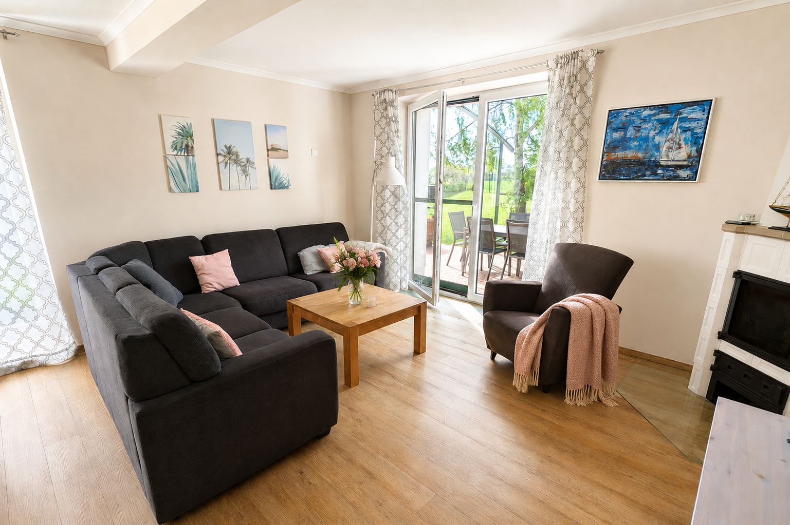 Wohnzimmer mit Ecksofa, Kamin und Zugang zur Terrasse im Ferienhaus Mira-Belle 1 in Kühlungsborn
