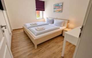 Doppelzimmer mit Doppelbett, Schreibtisch und TV im Ferienhaus Mira-Belle 2 in Kühlungsborn