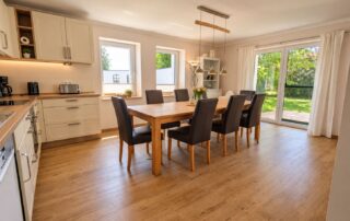 Offene Küche mit Esstisch für acht Personen und Terrassentür im Ferienhaus Mira-Belle 2