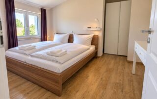 Schlafzimmer mit Doppelbett und großem Kleiderschrank im Ferienhaus Mira-Belle 2 in Kühlungsborn