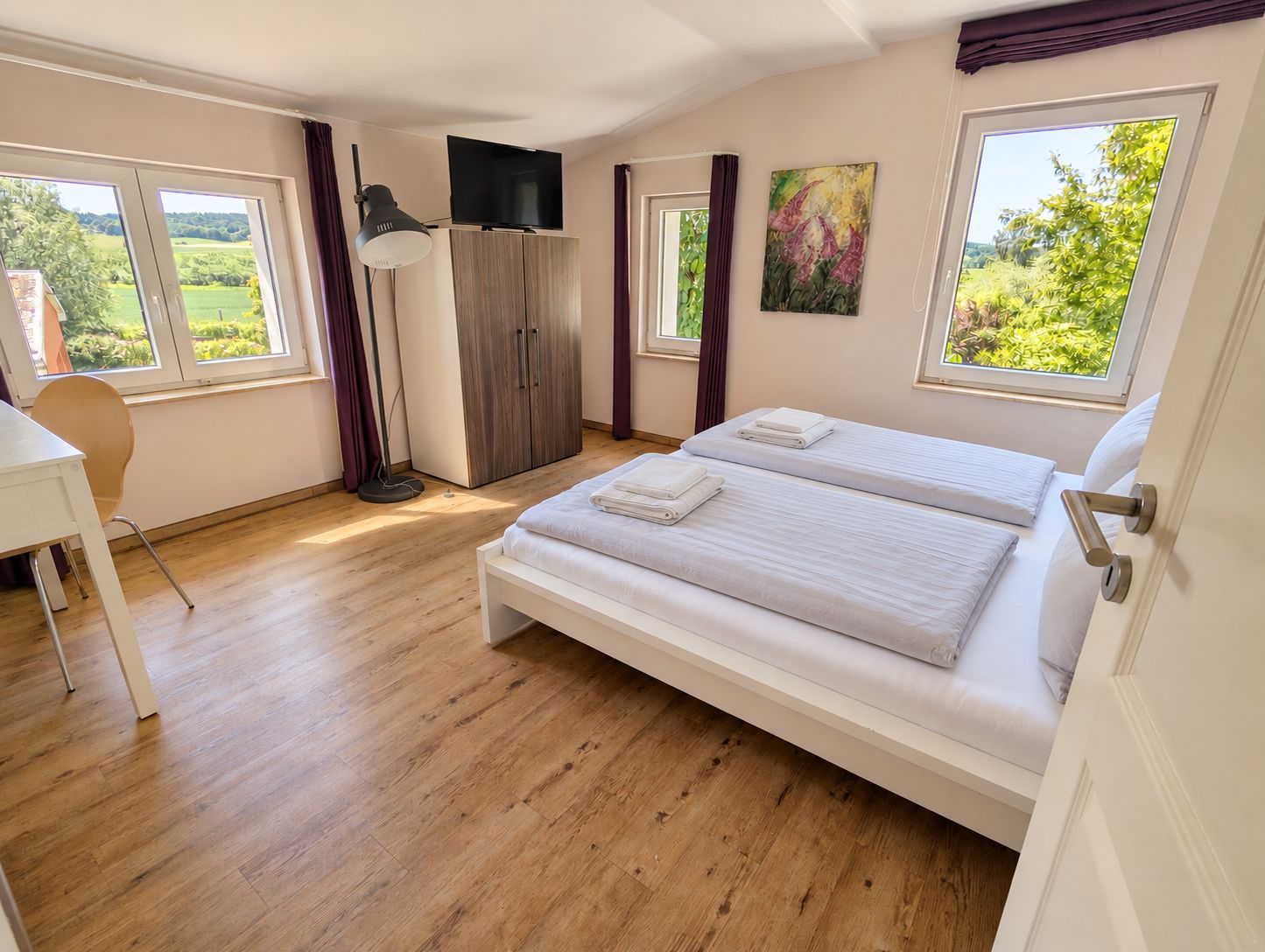 Helles Schlafzimmer mit Doppelbett und Blick ins Grüne im Ferienhaus Mira-Belle 2