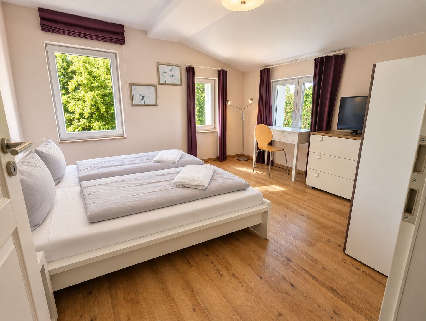 Schlafzimmer mit Doppelbett, Schreibtisch und TV im Ferienhaus Mira-Belle 2 an der Ostsee