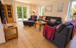 Gemütliches Wohnzimmer mit Sofas und Terrassenzugang im Ferienhaus Mira-Belle 2 in Kühlungsborn